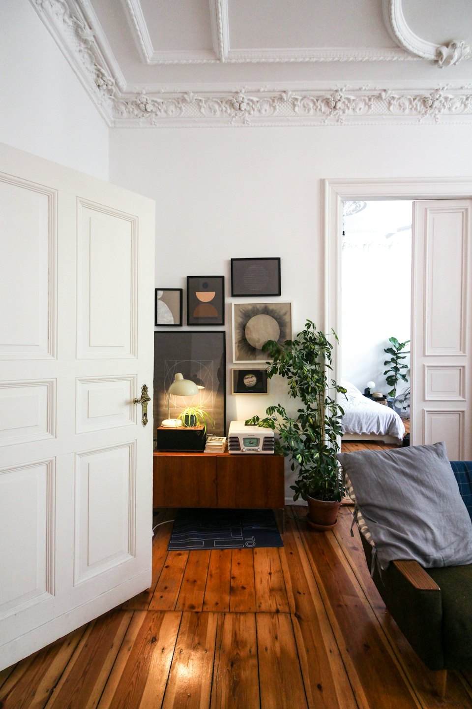Gemütliches Wohnzimmer mit Bilderwand und Pflanzen.