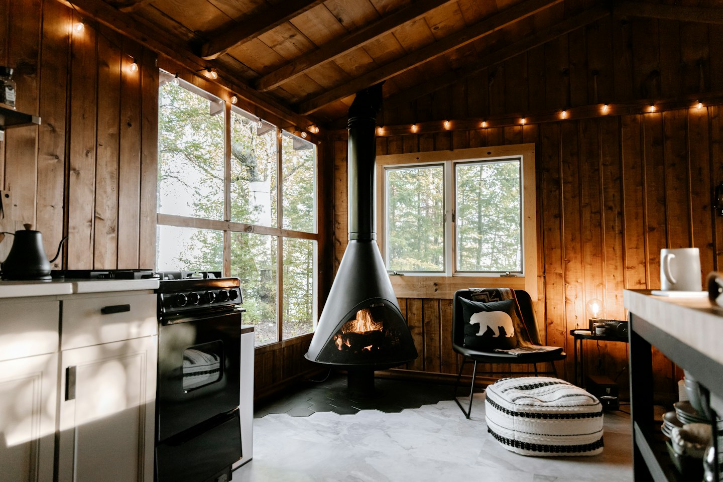 Rustikales Kabineninterieur mit Kamin und malerischem Fensterblick.